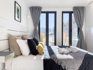 een slaapkamer met een bed met kussens en een raam bij Charming Stylish House w Mezzanine and Terrace in Porto