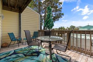 a patio with chairs and a table on a deck at 019 Sandcastle 4D in Dauphin Island