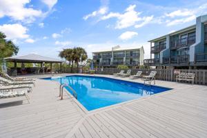 a swimming pool with lounge chairs next to a building at 019 Sandcastle 4D in Dauphin Island