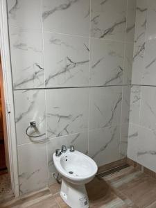 baño con lavabo blanco y paredes de mármol en Casa Supremo, en Concepción del Uruguay