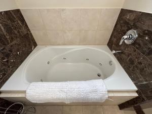 uma banheira branca na casa de banho com uma toalha em Wrigley Penthouse with Private Roof Deck and Parking em Chicago