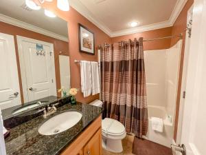 a bathroom with a sink and a toilet and a shower at 411 Holiday Isle 411 in Dauphin Island +9 photos