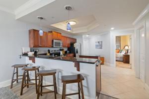 a kitchen with wooden cabinets and bar stools at 116 Holiday Isle in Dauphin Island