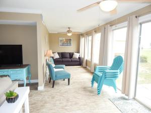 a living room with blue chairs and a couch at 065 Surf Club B5 in Dauphin Island