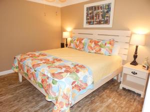 a bedroom with a bed with a floral bedspread at 065 Surf Club B5 in Dauphin Island +23 photos