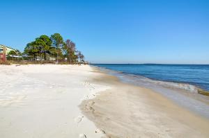 an empty beach with trees and the ocean at 065 Surf Club B5 in Dauphin Island