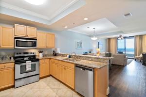 cocina con armarios de madera y sala de estar. en 521 Holiday Isle 521, en Dauphin Island