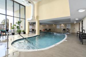 una piscina en medio de un vestíbulo del hotel con sillas en 521 Holiday Isle 521, en Dauphin Island