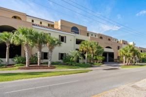 Un edificio con palmeras frente a una calle. en 521 Holiday Isle 521, en Dauphin Island