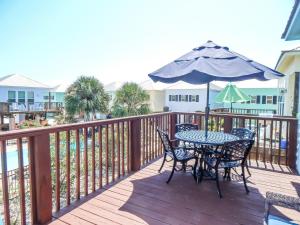 ein Tisch und Stühle mit einem Sonnenschirm auf einem Deck in der Unterkunft 070 Fish Camp 29 - Living the Dream in Dauphin Island