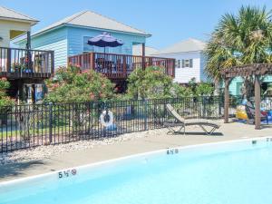 einen Pool mit einem Stuhl und einem Sonnenschirm in der Unterkunft 070 Fish Camp 29 - Living the Dream in Dauphin Island
