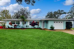 una casa con un césped verde delante de ella en Relax in Retro, en Clearwater
