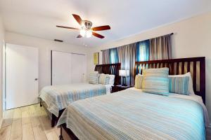 a bedroom with two beds and a ceiling fan at Relax in Retro in Clearwater