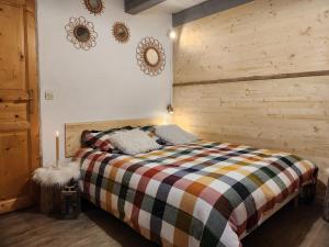 a bedroom with a bed with a wooden wall at Chalet d'Heïdi in Bourg-Saint-Maurice
