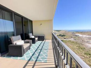 einen Balkon eines Hauses mit Stühlen und einem Tisch in der Unterkunft 604 Holiday Isle Beach Life in Dauphin Island