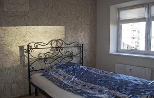 ein Schlafzimmer mit einem Bett mit einer blauen Decke darauf in der Unterkunft Real appartment in Vilnius