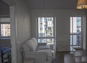 ein Wohnzimmer mit einem Stuhl und einem Glastisch in der Unterkunft Real appartment in Vilnius
