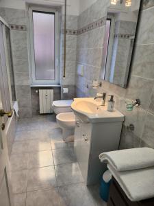 bagno con lavandino, servizi igienici e specchio di La Casa di Ari vicinissimo ospedale GASLINI GENOVA a Genova