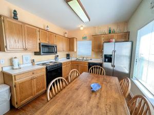a kitchen with a wooden table and a refrigerator at 039 Two Views in Dauphin Island