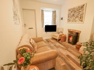 a living room with a couch and a fireplace at Castle Cottage in Lincoln