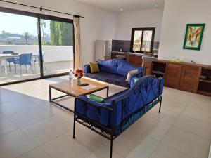 a living room with a blue couch and a table at Khelkom.lodge in Cap Skirring