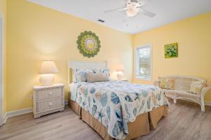 a bedroom with a bed and two lamps and a chair at 025 The Sanderling in Dauphin Island