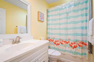 a bathroom with a toilet and a shower curtain at 025 The Sanderling in Dauphin Island +27 photos
