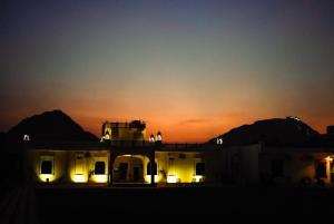 un edificio con luces frente a la puesta de sol en The Ashok Heritage Resort & Retreat, en Pushkar