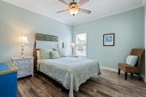 Un dormitorio con una cama y un ventilador de techo. en 024 Casita Rosa, en Dauphin Island 20 fotos más