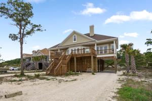 a house with a wrap around porch on the beach at 025 The Sanderling in Dauphin Island