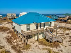 a house with a blue roof on a beach at 078 Lazy Bass in Dauphin Island