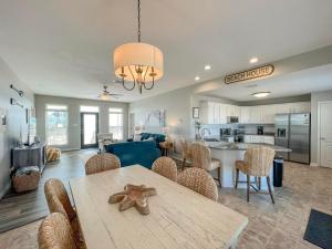 a dining room and kitchen with a table and chairs at 078 Lazy Bass in Dauphin Island