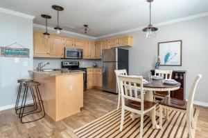 una cucina con mobili in legno e un tavolo con sedie di 073 Coastal Cottage a Dauphin Island