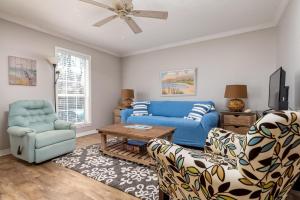 un soggiorno con divano blu e 2 sedie di 073 Coastal Cottage a Dauphin Island