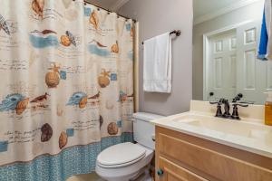 un bagno con un water, un lavandino e una tenda da doccia di 073 Coastal Cottage a Dauphin Island Altre 8 foto