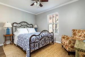 una camera da letto con un letto e una sedia di 073 Coastal Cottage a Dauphin Island