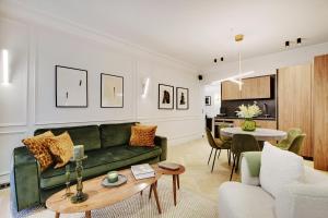 un soggiorno con divano verde e tavolo di TheLander - Champs Elysées Serviced Apartments a Parigi