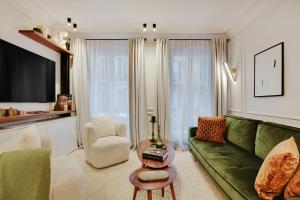 un soggiorno con divano verde e sedia di TheLander - Champs Elysées Serviced Apartments a Parigi