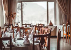 a dining room with tables and chairs and a large window at Hotel IP Swarn near Anand Vihar Vaishali Ghaziabad in Ghaziabad