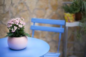 um vaso com flores numa mesa com uma cadeira azul em Blue Courtyard HOWME em Bari