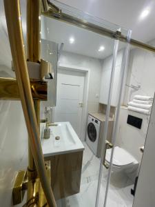 łazienka z umywalką i pralką w obiekcie Golden Queen Aparthotel PARKING w Kielcach