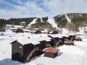 un groupe de bâtiments dans la neige avec de la neige dans l'établissement Fin lägenhet med bastu i Järvsö!, à Järvsö