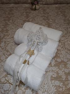 un grupo de toallas blancas en una cama en Mary's Dreamy Maisonette, en Volos