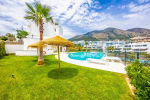 a yard with a pool and a palm tree at 96-brand new apartment, Fuengirola in Fuengirola