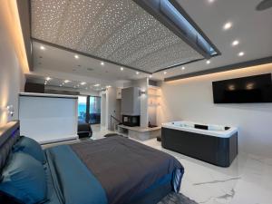 - une chambre avec un lit et un écran de projection dans l'établissement Seafront Luxury Suite with Jacuzzi & Sauna, à Monemvasia