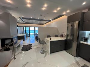 a kitchen with black cabinets and white tile floors at Seafront Luxury Suite with Jacuzzi & Sauna in Monemvasia