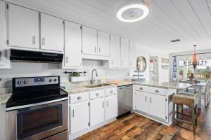 cocina con armarios blancos y fogones en 017 The Sand House, en Dauphin Island