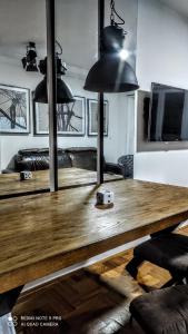 a wooden table in a living room with black lights at Budva apartman Haustor in Budva