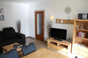 uma sala de estar com um sofá e uma televisão em Fewo Nordseestraße 5 em Büsum