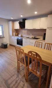 a kitchen with a wooden table and chairs at Fewo Voßeler in Büsum